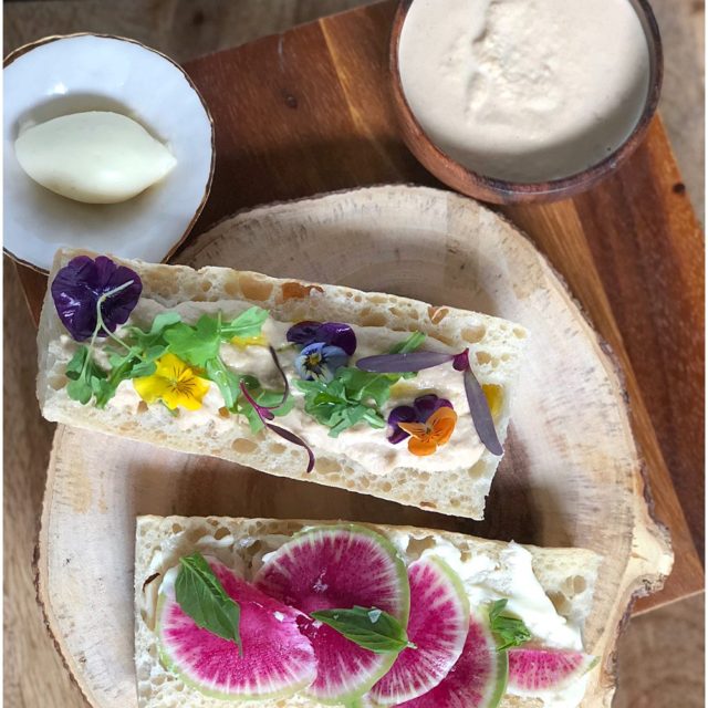 Smoked butter on sliced baguette topped with radishes and edible pansies